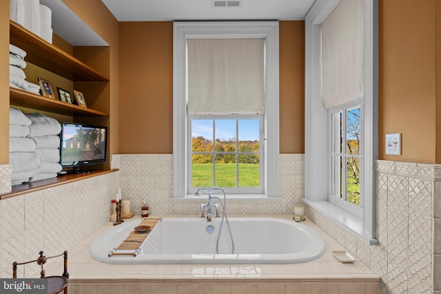 bathroom with a relaxing tiled tub