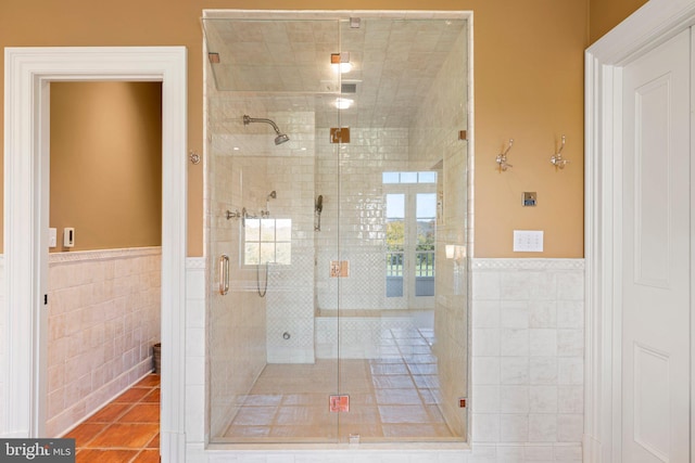 bathroom featuring tile patterned flooring, tile walls, and walk in shower