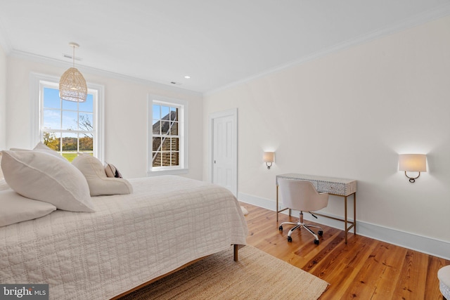 bedroom with ornamental molding and hardwood / wood-style flooring