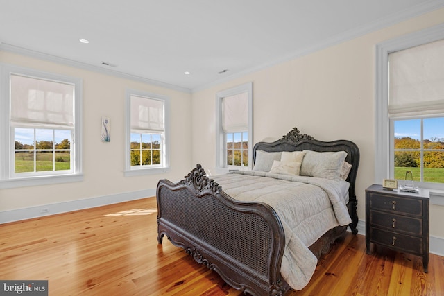 bedroom with hardwood / wood-style flooring and crown molding