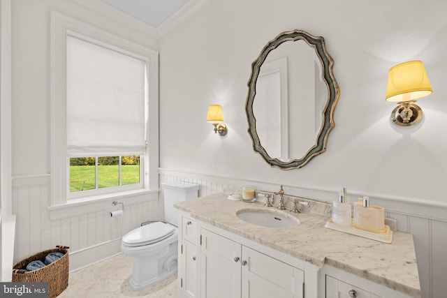 bathroom featuring toilet, vanity, and ornamental molding