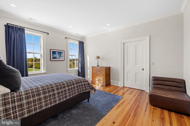 bedroom with light hardwood / wood-style flooring and ornamental molding