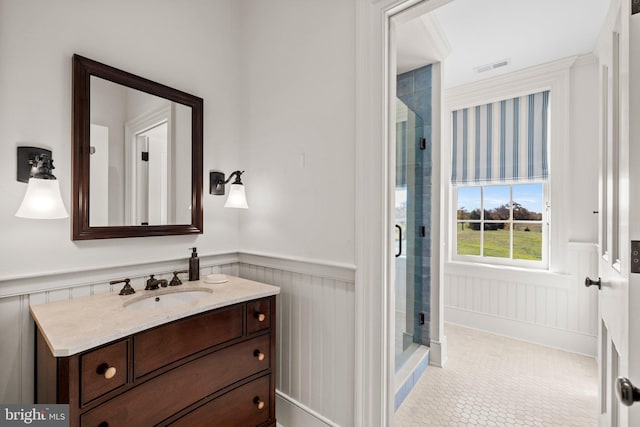 bathroom featuring tile patterned floors, vanity, and a shower with door