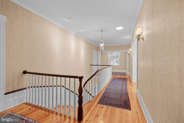 corridor with hardwood / wood-style floors and crown molding