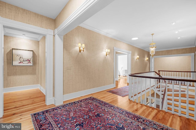 hallway with wood-type flooring and ornamental molding