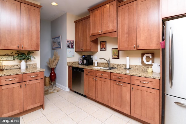 kitchen with light tile patterned flooring, sink, light stone counters, and appliances with stainless steel finishes