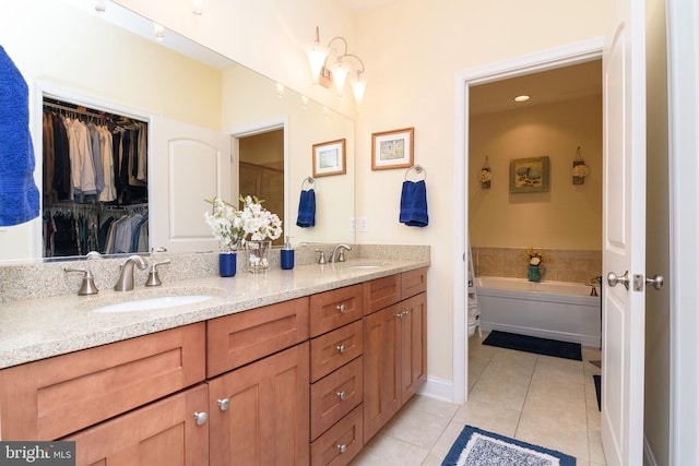 bathroom with tile patterned flooring, vanity, and a tub