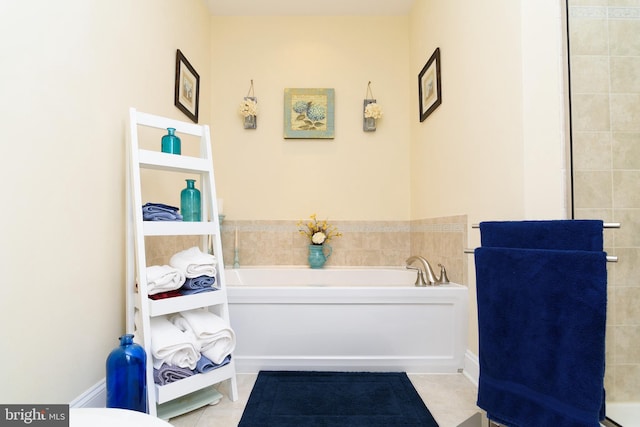 bathroom with a tub to relax in and tile patterned flooring