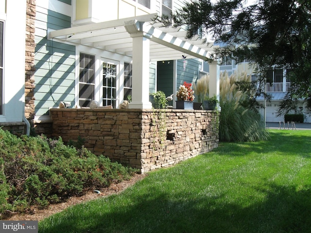 view of side of home with a pergola and a yard