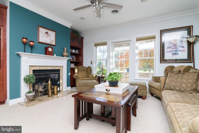 carpeted living room featuring ornamental molding, ceiling fan, and a high end fireplace