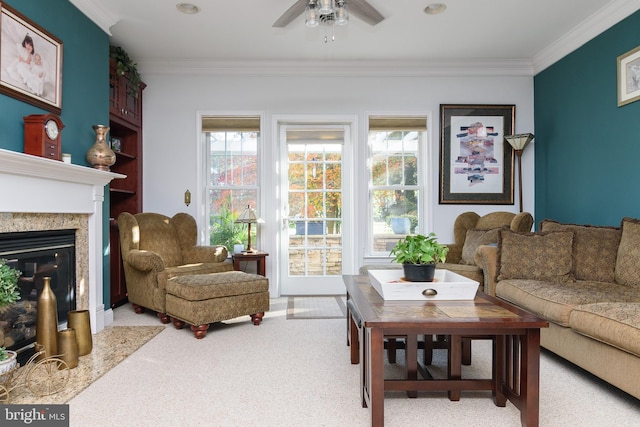 living room with a high end fireplace, light carpet, ceiling fan, and crown molding