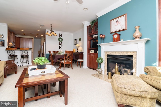 carpeted living room featuring a fireplace, ceiling fan, and crown molding