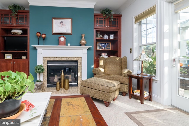 living area with wood-type flooring, a high end fireplace, and ornamental molding