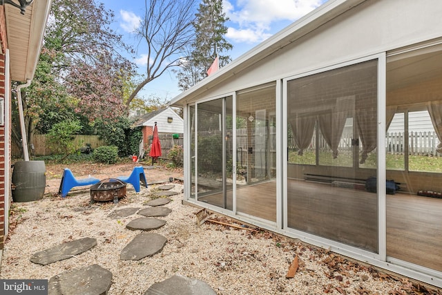 view of patio with a fire pit and a sunroom