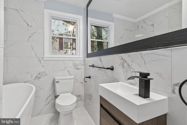 bathroom featuring toilet, vanity, crown molding, and a tub to relax in