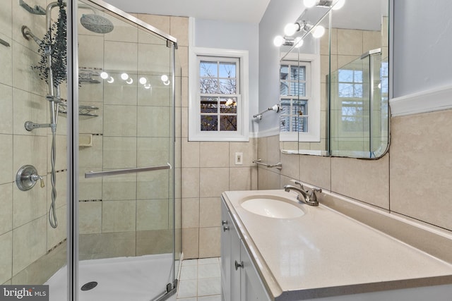 bathroom featuring vanity, tile walls, and a shower with shower door