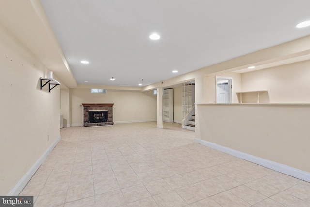 basement featuring light tile patterned flooring and a fireplace