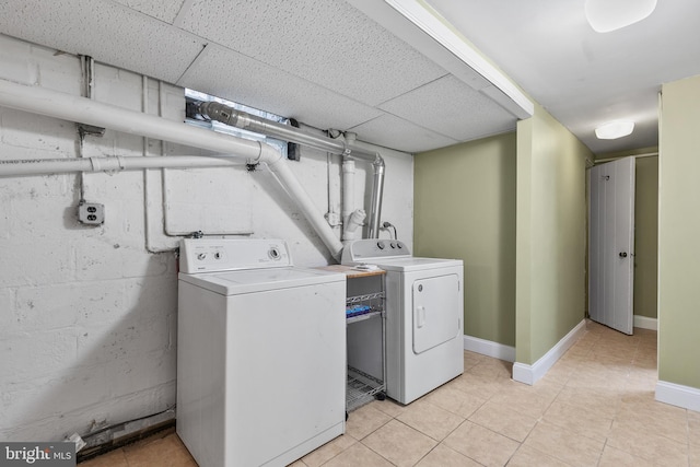 clothes washing area with independent washer and dryer and light tile patterned floors