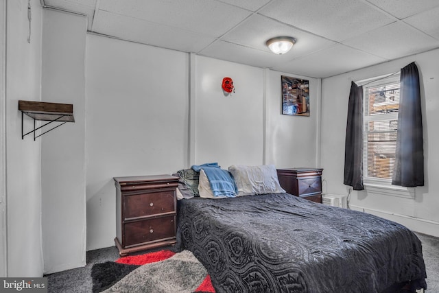 carpeted bedroom with a drop ceiling