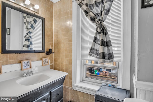 bathroom featuring vanity and tile walls