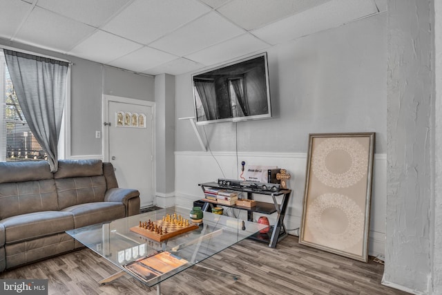 living room featuring a drop ceiling and hardwood / wood-style floors