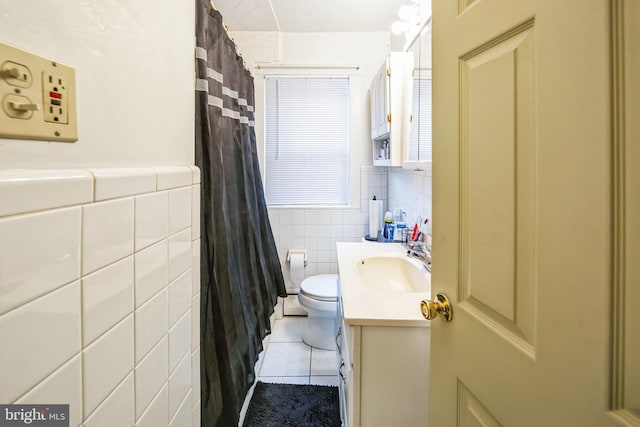 bathroom with toilet, tile patterned flooring, tile walls, vanity, and curtained shower