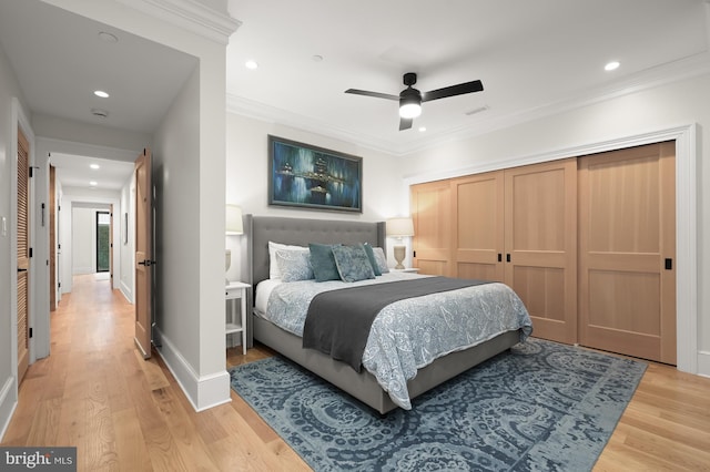 bedroom with ceiling fan, light hardwood / wood-style floors, a closet, and ornamental molding