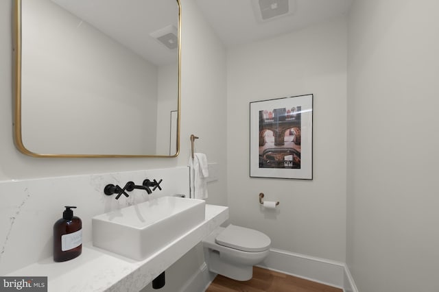 bathroom featuring sink, hardwood / wood-style floors, and toilet