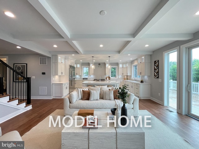 living room with sink, coffered ceiling, beam ceiling, and hardwood / wood-style floors