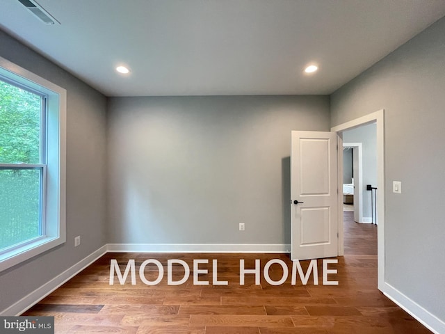 spare room with wood-type flooring and a wealth of natural light