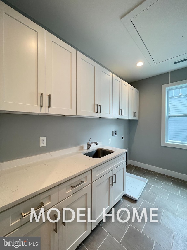 clothes washing area with washer hookup, dark tile patterned flooring, sink, electric dryer hookup, and cabinets