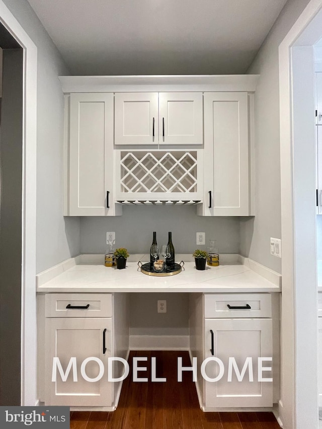 bar featuring white cabinets and dark hardwood / wood-style floors