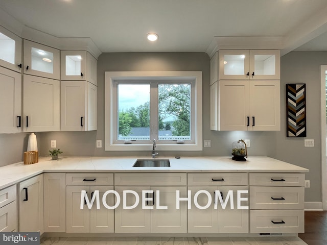 kitchen with sink, white cabinets, and light stone counters