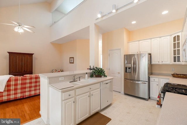 kitchen featuring white cabinetry, appliances with stainless steel finishes, high vaulted ceiling, sink, and light hardwood / wood-style flooring