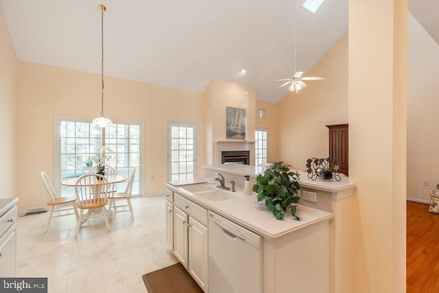 kitchen with high vaulted ceiling, plenty of natural light, sink, and dishwasher