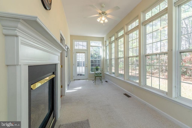 unfurnished sunroom with a healthy amount of sunlight and ceiling fan