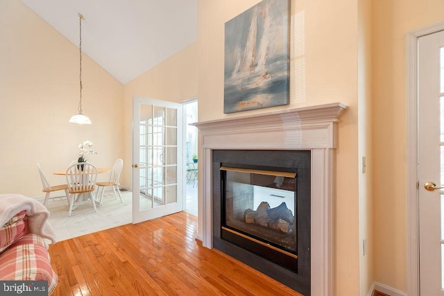 unfurnished living room with hardwood / wood-style floors and high vaulted ceiling