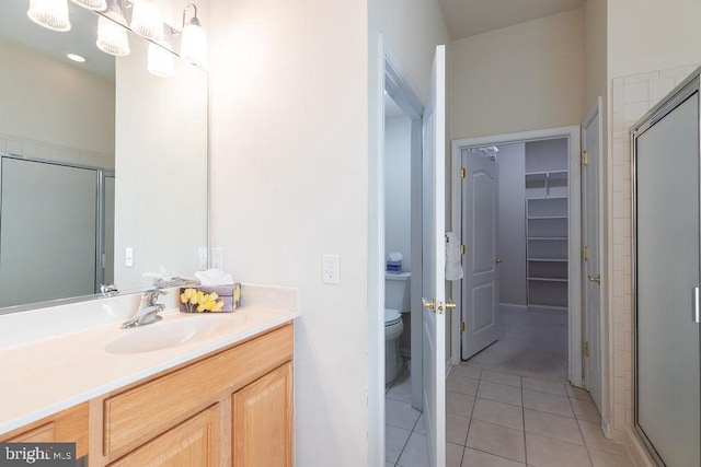 bathroom featuring toilet, vanity, tile patterned flooring, and walk in shower