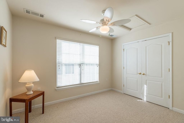 bedroom featuring light colored carpet, ceiling fan, and a closet