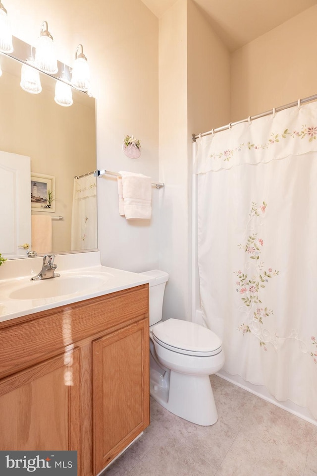 bathroom with tile patterned flooring, vanity, and toilet