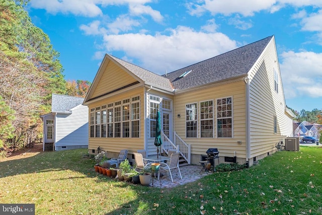 back of house with central AC and a yard