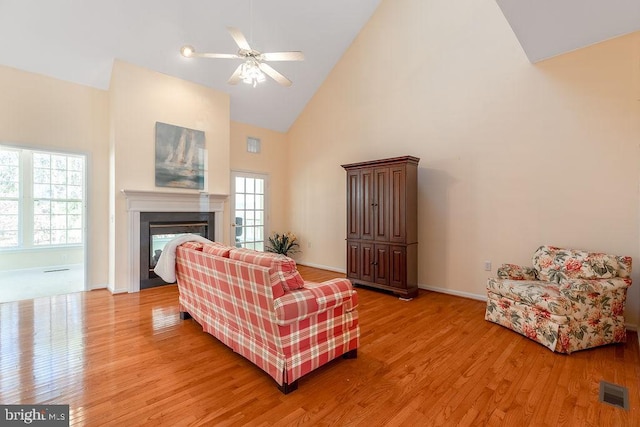 living room featuring high vaulted ceiling, ceiling fan, a wealth of natural light, and light hardwood / wood-style floors