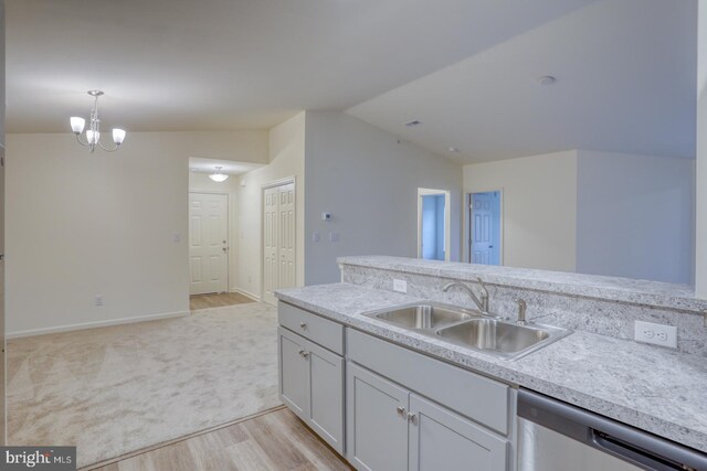 kitchen with lofted ceiling, dishwasher, sink, light carpet, and decorative light fixtures