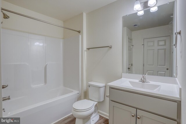 full bathroom with  shower combination, wood-type flooring, toilet, and vanity