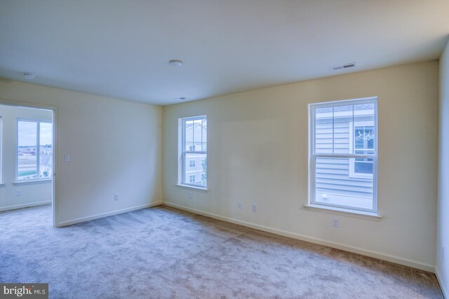 empty room with a wealth of natural light and light colored carpet