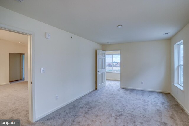 unfurnished room featuring light carpet