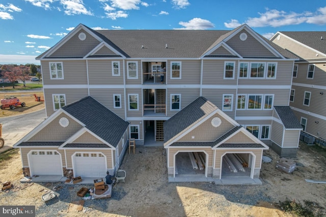 5003 E Pebble Ln Unit J, Milford, DE 19963 - view of front of property featuring a shingled roof, central AC unit, and stone siding