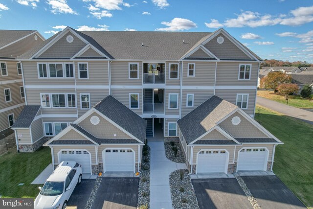 view of front of house with a front lawn and a balcony