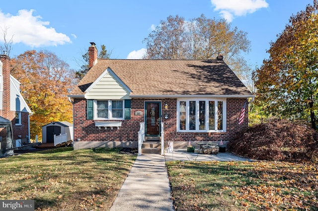 view of front of house featuring a shed, a front lawn, and a patio area