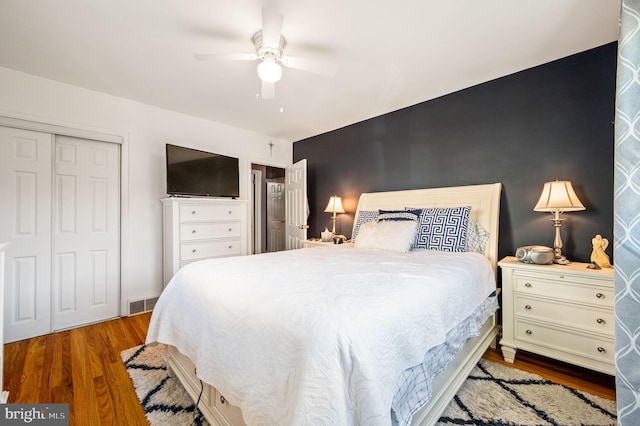 bedroom with wood-type flooring, ceiling fan, and a closet